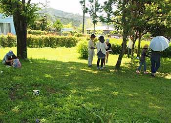 参加者が吉澤記念美術館のまわりでフロタージュに使う木や花、草を採取している様子の写真